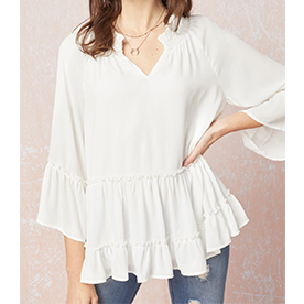 V-neck tiered top featuring smocking detail at neckline. Lined and Non-sheer. 